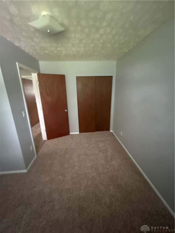 unfurnished bedroom with carpet flooring and a textured ceiling