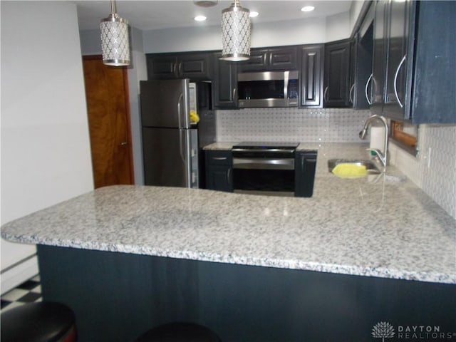 11031 N Montgmy Co L Rd, Union Twp, OH 45309 - kitchen with stainless steel appliances, a peninsula, tasteful backsplash, and a sink