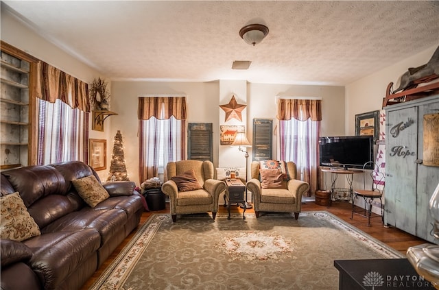 living room featuring dark hardwood / wood-style flooring and a textured ceiling