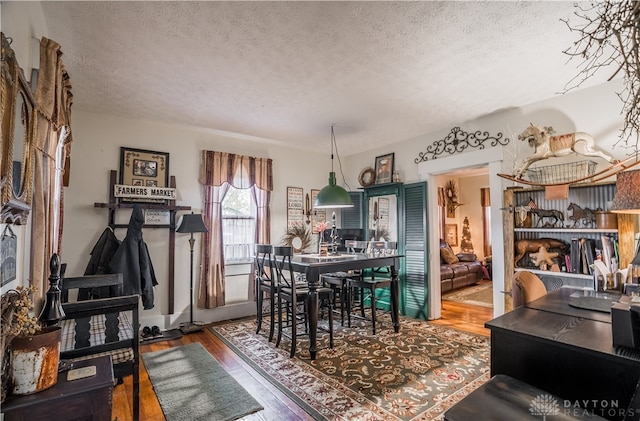 dining area with a textured ceiling and hardwood / wood-style flooring