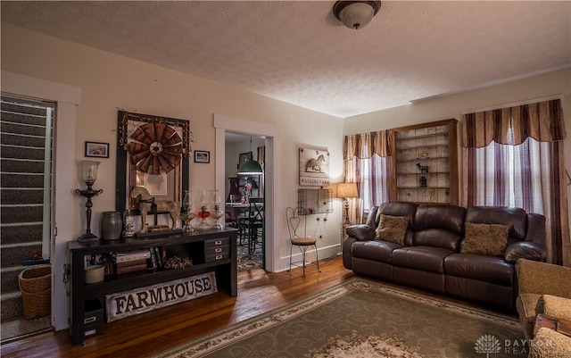 living room featuring a textured ceiling, a wealth of natural light, and dark wood-type flooring