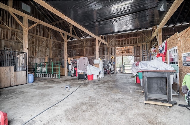 miscellaneous room featuring concrete flooring and high vaulted ceiling