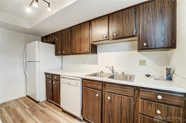 kitchen featuring dark brown cabinets, sink, white appliances, and light wood-type flooring