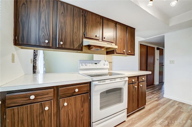 kitchen with white range with electric stovetop, light hardwood / wood-style floors, and kitchen peninsula