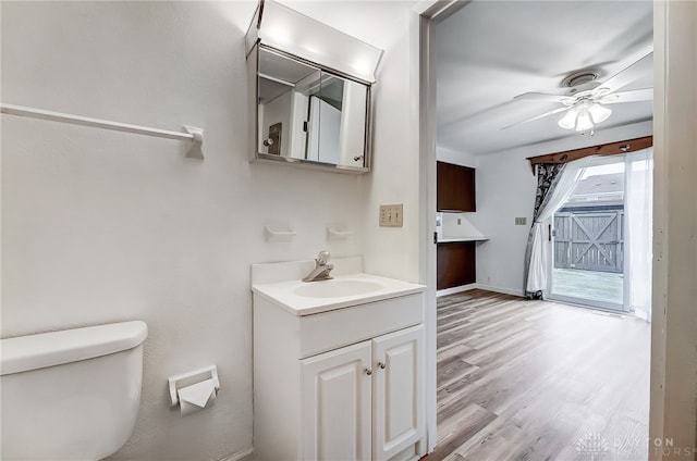 bathroom featuring ceiling fan, toilet, vanity, and hardwood / wood-style flooring