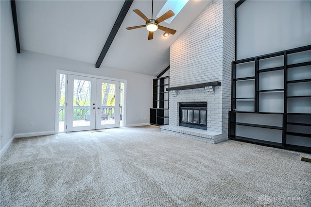 unfurnished living room with a fireplace, high vaulted ceiling, carpet flooring, and french doors