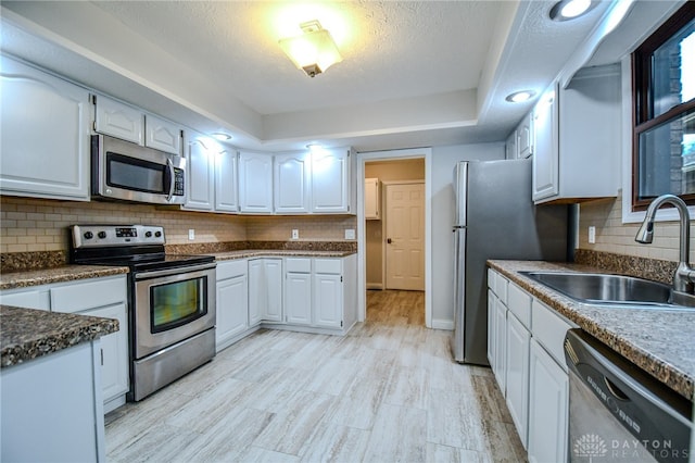 kitchen featuring white cabinets, sink, stainless steel appliances, and tasteful backsplash