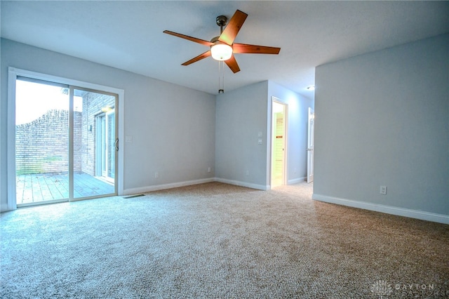 spare room featuring visible vents, carpet flooring, a ceiling fan, and baseboards