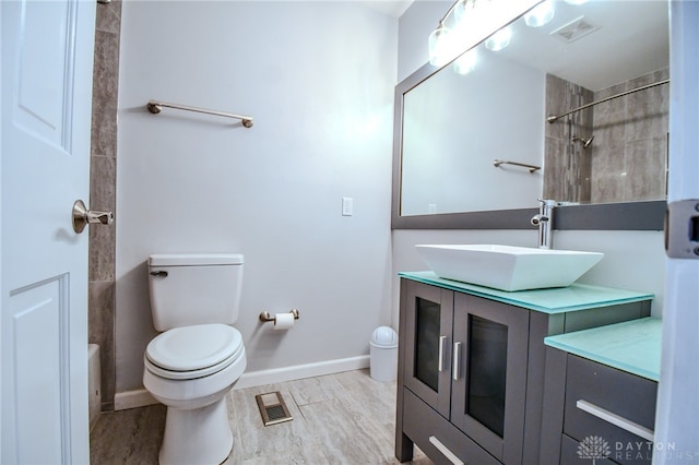 full bathroom featuring toilet, baseboards, visible vents, and vanity