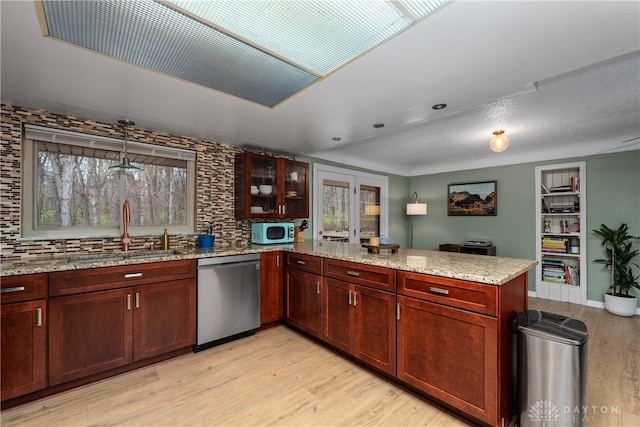 kitchen with dishwasher, light hardwood / wood-style floors, a wealth of natural light, and sink