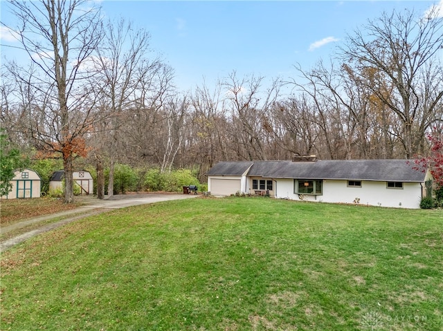 view of front of property with a storage shed and a front lawn