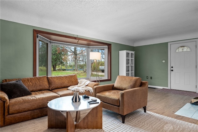 living room featuring a textured ceiling and light hardwood / wood-style floors