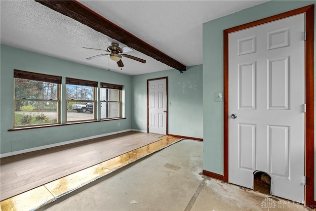 foyer entrance with beam ceiling, a textured ceiling, and ceiling fan