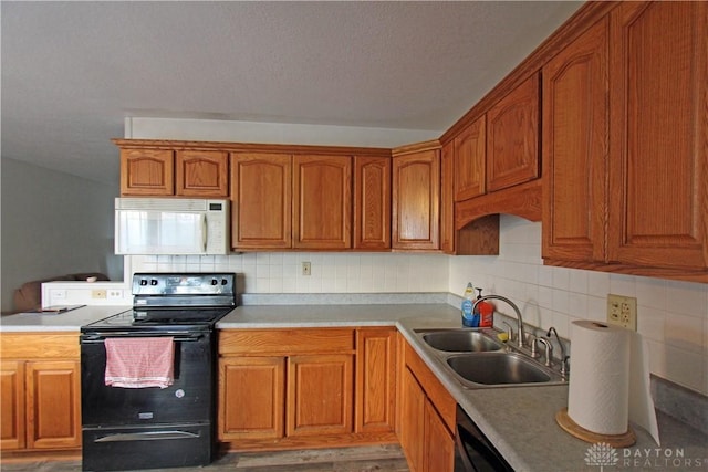 kitchen with sink, decorative backsplash, black appliances, and light hardwood / wood-style floors