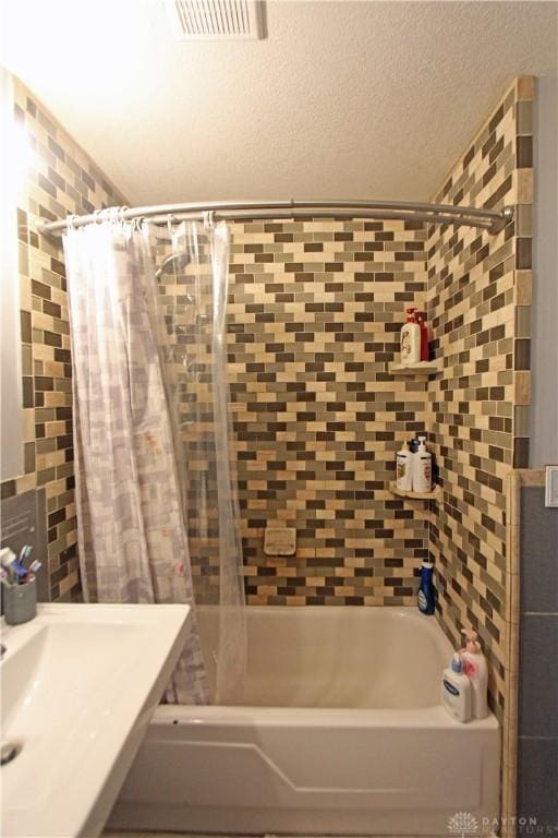 bathroom with sink, decorative backsplash, a textured ceiling, and shower / bath combo with shower curtain