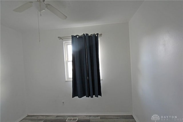 unfurnished room with ceiling fan and dark hardwood / wood-style floors