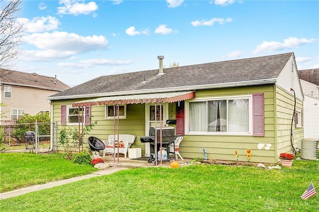 back of house with a lawn, central AC unit, and a patio