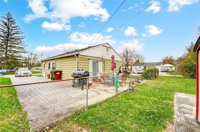 rear view of property featuring a patio and a lawn