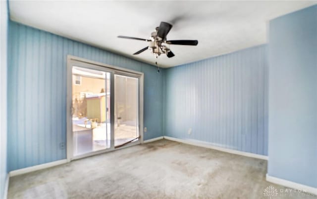 carpeted spare room featuring ceiling fan