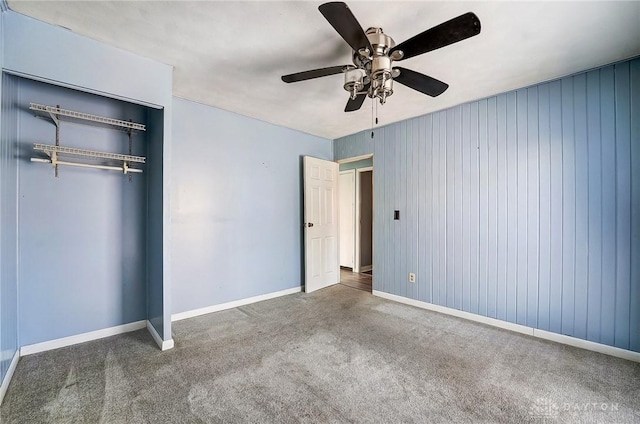 unfurnished bedroom with dark carpet, ceiling fan, and a closet