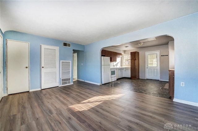 unfurnished living room with dark wood-type flooring