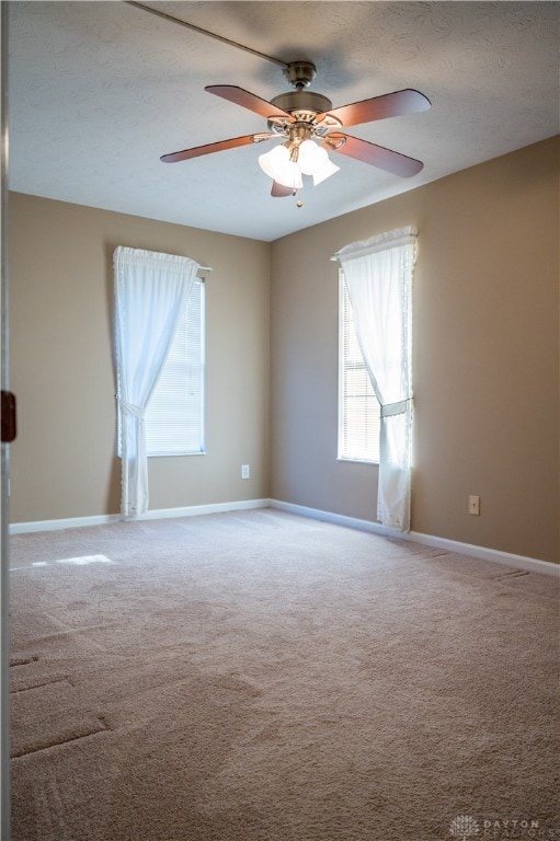 carpeted empty room with ceiling fan and a textured ceiling