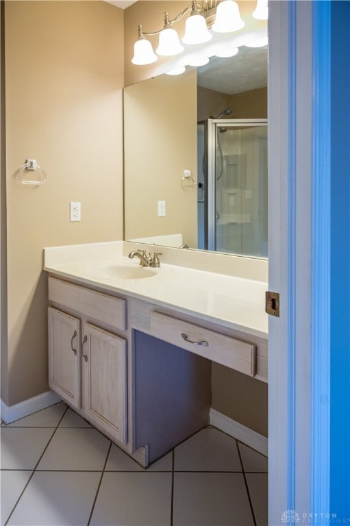 bathroom featuring tile patterned flooring, vanity, and walk in shower