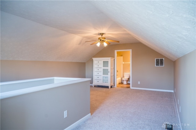 additional living space with ceiling fan, light colored carpet, and vaulted ceiling