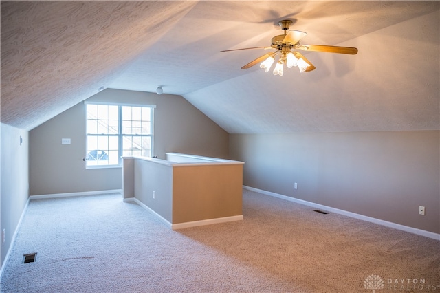 additional living space with ceiling fan, light carpet, and vaulted ceiling