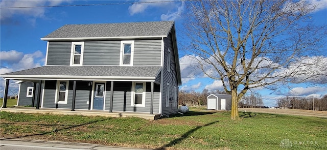 view of front of house with covered porch, a storage shed, and a front yard