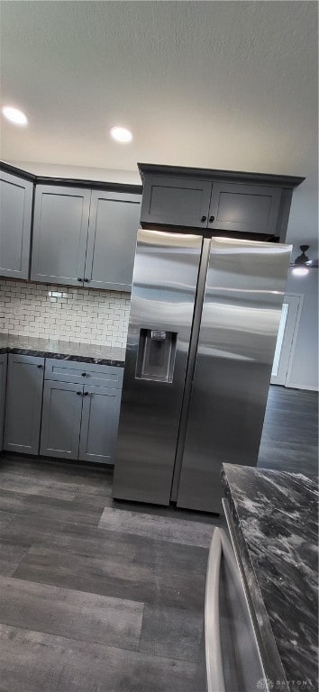 kitchen featuring gray cabinets, stainless steel fridge, dark hardwood / wood-style flooring, and backsplash