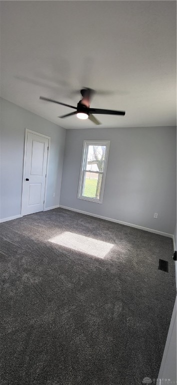 unfurnished room with carpet flooring and ceiling fan