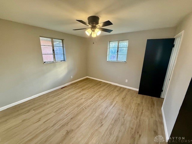 spare room with ceiling fan and light wood-type flooring