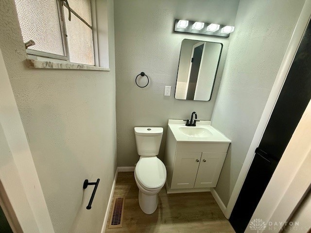 bathroom featuring hardwood / wood-style floors, vanity, and toilet