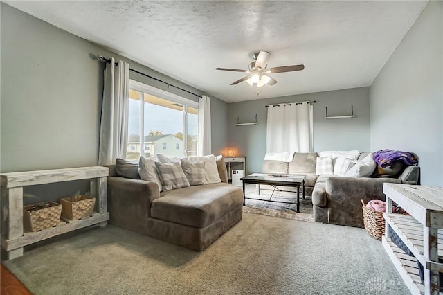 carpeted living room featuring ceiling fan and a textured ceiling