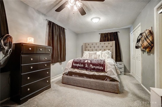 carpeted bedroom featuring ceiling fan, a closet, and a textured ceiling