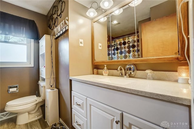 bathroom with vanity, hardwood / wood-style flooring, and toilet