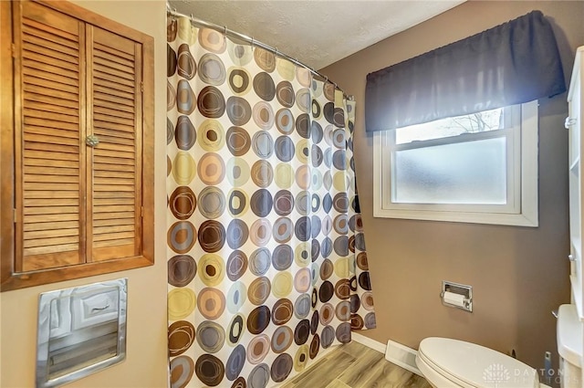 bathroom featuring toilet, a shower with shower curtain, a textured ceiling, and hardwood / wood-style flooring