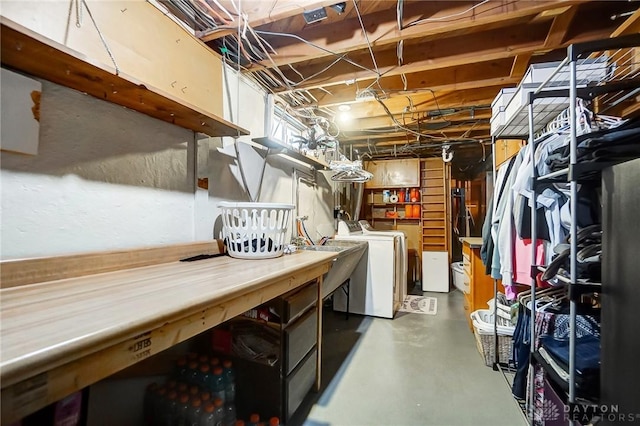 basement with sink, a workshop area, and washing machine and clothes dryer