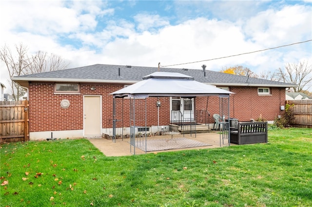 back of house featuring a gazebo, a patio area, and a lawn