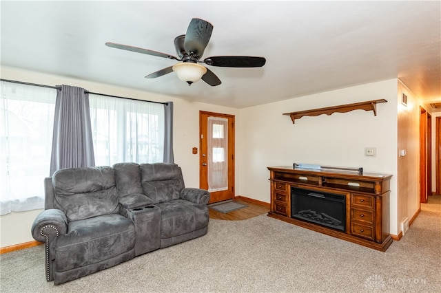 carpeted living room with ceiling fan