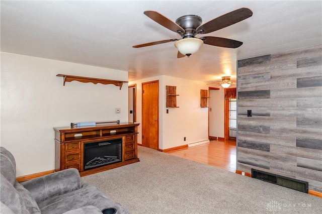 living room with light hardwood / wood-style flooring, baseboard heating, and wood walls