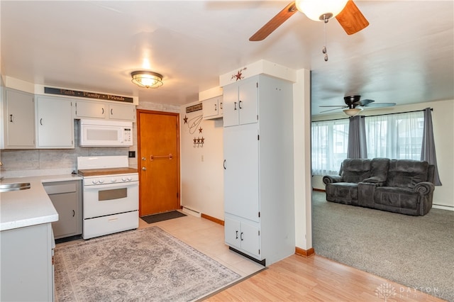 kitchen featuring light wood-type flooring, white appliances, gray cabinets, and backsplash