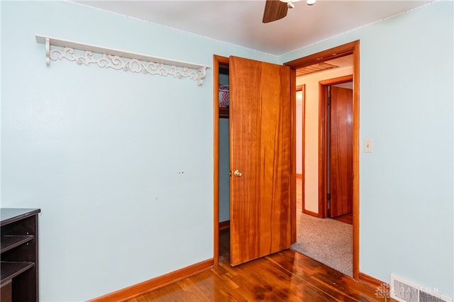 unfurnished bedroom featuring ceiling fan and dark hardwood / wood-style flooring