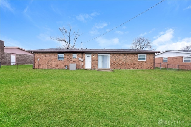 back of property with cooling unit and a yard