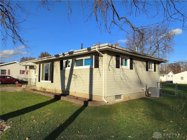 view of home's exterior featuring central AC unit and a lawn