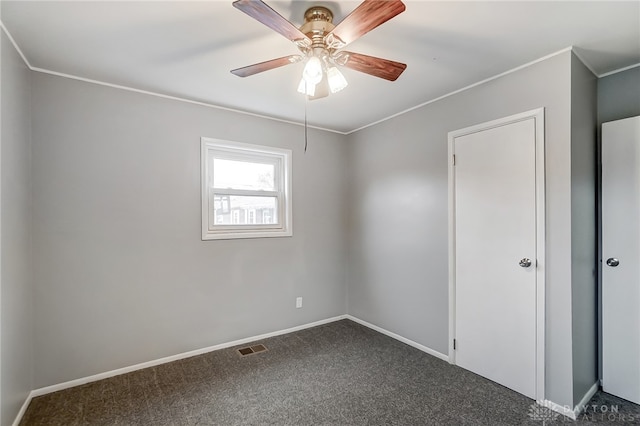 unfurnished bedroom with ceiling fan, crown molding, and dark carpet