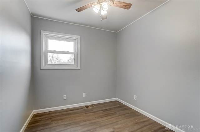 unfurnished room with dark hardwood / wood-style floors, ceiling fan, and ornamental molding