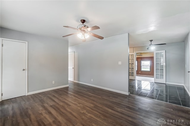 empty room featuring ceiling fan, french doors, and dark wood-type flooring