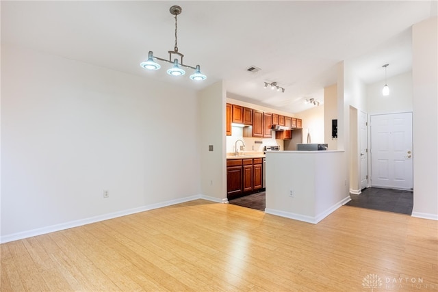 kitchen featuring hanging light fixtures, lofted ceiling, and light wood-type flooring